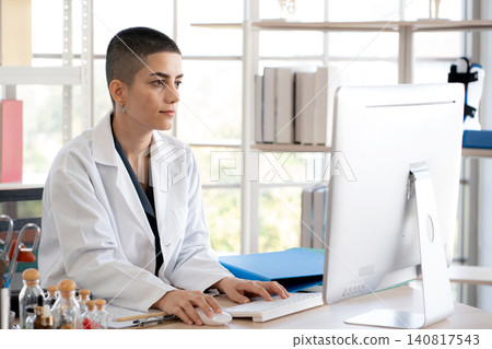 professional woman doctor sitting working with computer looking at monitor. professional woman doctor sitting working with computer looking at monitor. 140817543