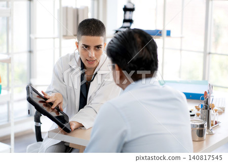 Woman doctor discussing illness symptom of man patient at clinic looking tablet. Woman doctor discussing illness symptom of man patient at clinic looking tablet. 140817545