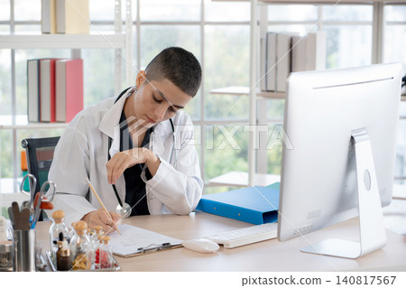 Caucasian woman doctor sitting and working with computer monitor and record document. 140817567