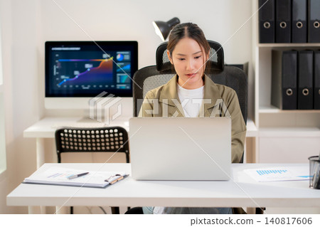 Asian businesswoman sitting working on laptop at office. Asian businesswoman sitting working on laptop at office. 140817606