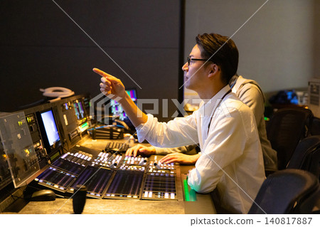 A director working in a broadcasting station's control room 140817887