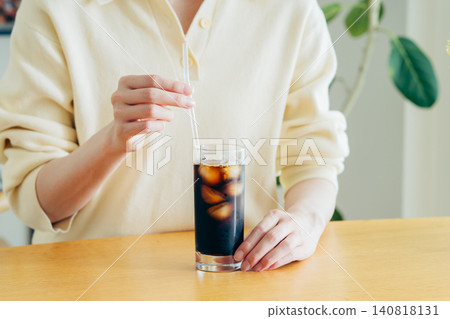 年輕女子在家喝冰咖啡時的雙手。 年輕女子在家喝冰咖啡時的雙手。 140818131