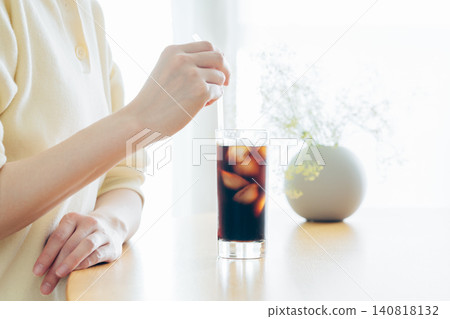 年輕女子在家喝冰咖啡時的雙手。 140818132