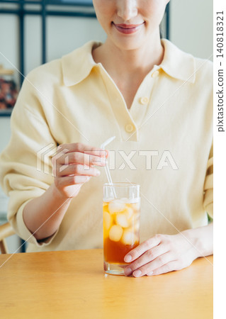 年輕女子在家喝冰茶時的雙手。 年輕女子在家喝冰茶時的雙手。 140818321