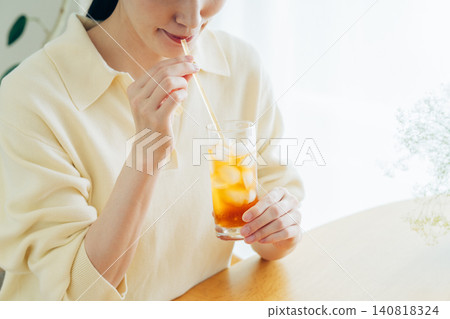 年輕女子在家喝冰茶時的雙手。 年輕女子在家喝冰茶時的雙手。 140818324