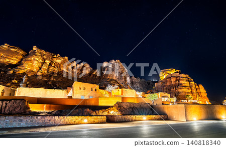 A stunning night view of the illuminated mud brick buildings and ancient fort of AlUla Old Town set against a starry sky in Saudi Arabia. A stunning night view of the illuminated mud brick buildings and ancient fort of AlUla Old Town set against a starry sky in Saudi Arabia. 140818340