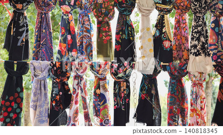 Colorful pashminas hanging in a market stall in India are creating a vibrant and textured display 140818345