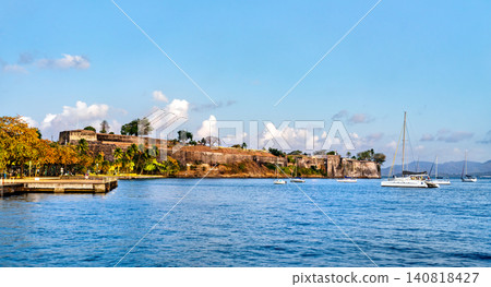 Scenic view of the historic Fort Saint Louis fortification on the coast of Fort de France, Martinique, seen from the bay with sailboats on the blue water. Scenic view of the historic Fort Saint Louis fortification on the coast of Fort de France, Martinique, seen from the bay with sailboats on the blue water. 140818427