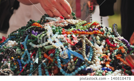 Hand selecting colorful beaded necklaces and jewelry at an India Day market in Moscow 140818478