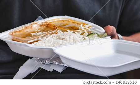 Person holding Indian street food takeaway with basmati rice and curry during India Day in Moscow Person holding Indian street food takeaway with basmati rice and curry during India Day in Moscow 140818510