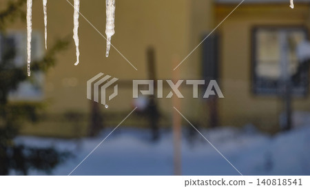 Icicles melting in hard winter outdoor, water dripping from frozen house roof Icicles melting in hard winter outdoor, water dripping from frozen house roof 140818541