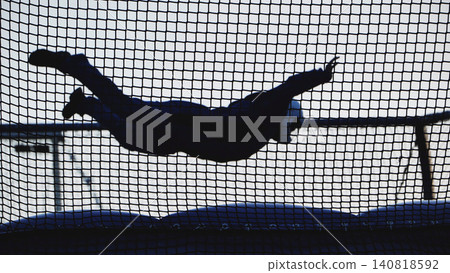 Skydiving simulator silhouette flying in a vertical wind tunnel during indoor training Skydiving simulator silhouette flying in a vertical wind tunnel during indoor training 140818592