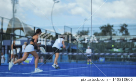 Padel players competing on blue court, engaging in intense action and sport match Padel players competing on blue court, engaging in intense action and sport match 140818606