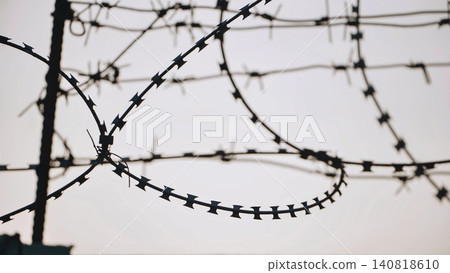 Razor wire protecting a secure perimeter fence in Moscow, symbolizing restriction Razor wire protecting a secure perimeter fence in Moscow, symbolizing restriction 140818610
