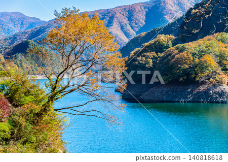 Lake Okutama in Tokyo is ablaze with autumn colors. Lake Okutama in Tokyo is ablaze with autumn colors. 140818618