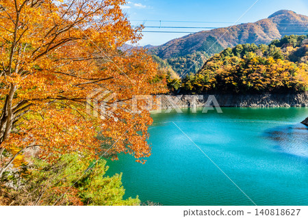 Lake Okutama in Tokyo is ablaze with autumn colors. Lake Okutama in Tokyo is ablaze with autumn colors. 140818627