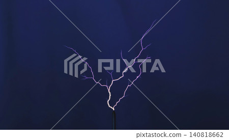 Tesla coil generating high voltage electrical discharge with branching purple sparks 140818662