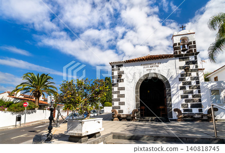 Traditional Spanish architecture of the historic San Amaro church in Puerto de la Cruz, Tenerife. The sixteenth century building features white walls and stone arches under a blue sky. 140818745