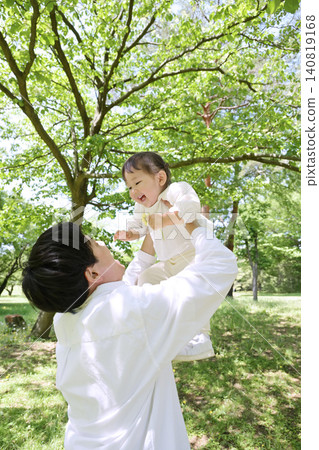 A young father lifts his beloved daughter up in the air. 140819168