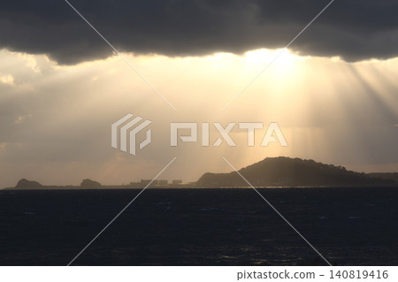 神聖天使的天梯從雲層縫隙中垂落到大海和島嶼上，構成了一幅壯觀的景象。 140819416
