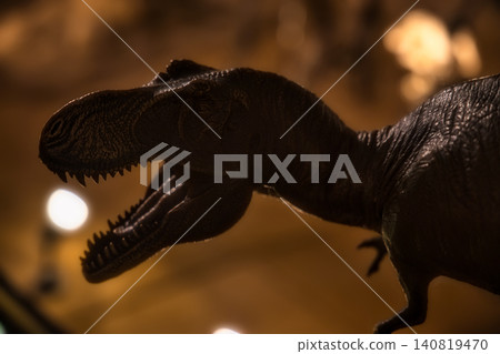 The profile of a Tyrannosaurus Rex emerges dramatically from the darkness, illuminated by lights. The profile of a Tyrannosaurus Rex emerges dramatically from the darkness, illuminated by lights. 140819470