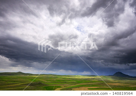 Stormy sky above open countryside with green fields and hills Stormy sky above open countryside with green fields and hills 140819564
