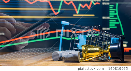 Global oil market crash concept. Overturned shopping cart, spilled oil barrels, and fallen trophy against a declining financial stock chart. Global oil market crash concept. Overturned shopping cart, spilled oil barrels, and fallen trophy against a declining financial stock chart. 140819955
