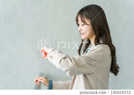 A businesswoman in a suit looking at a wristwatch or smartwatch A businesswoman in a suit looking at a wristwatch or smartwatch 140820532