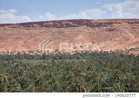 A panoramic view of the Aoufous palm grove showcases the lush oasis nestled among the mountains of Morocco. 140820777