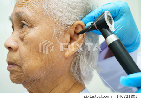 Otolaryngologist or ENT physician doctor examining senior patient ear with otoscope, hearing loss problem. Otolaryngologist or ENT physician doctor examining senior patient ear with otoscope, hearing loss problem. 140821805