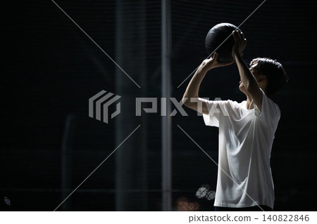 籃球運動員在夜間球場上練習或嘗試跳投的照片;沒有臉部的側臉。 籃球運動員在夜間球場上練習或嘗試跳投的照片;沒有臉部的側臉。 140822846