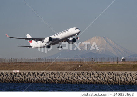An A350 takes off from runway D at Haneda Airport with Mount Fuji in the background. 140823668