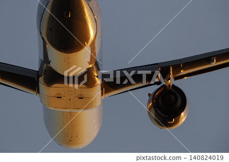 An airplane bathed in the red light of the setting sun. An airplane bathed in the red light of the setting sun. 140824019