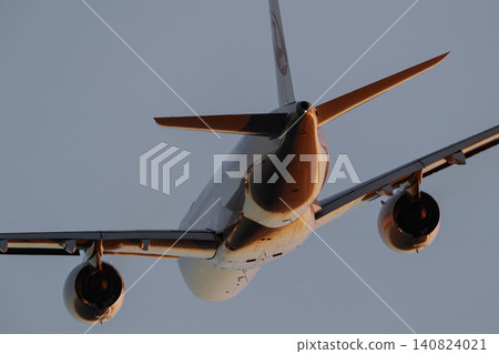 An airplane bathed in the red light of the setting sun. 140824021