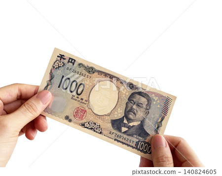 A woman's hand holding a thousand yen bill with both hands A woman's hand holding a thousand yen bill with both hands 140824605