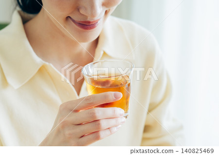 年輕女子在家喝大麥茶時的雙手。 年輕女子在家喝大麥茶時的雙手。 140825469