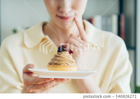 A young woman's hands as she eats Mont Blanc. A young woman's hands as she eats Mont Blanc. 140826271