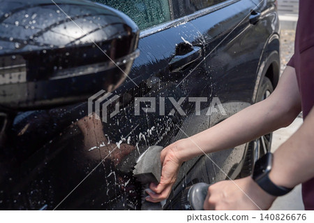 A man's hand washing a car A man's hand washing a car 140826676
