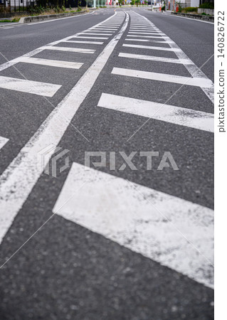 A residential street with continuous road markings and traffic guides | Traffic rules and safe driving image A residential street with continuous road markings and traffic guides | Traffic rules and safe driving image 140826722