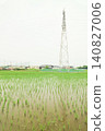 A rice paddy just after planting, with a power transmission tower towering in the background, as rain falls during the rainy season. 140827006