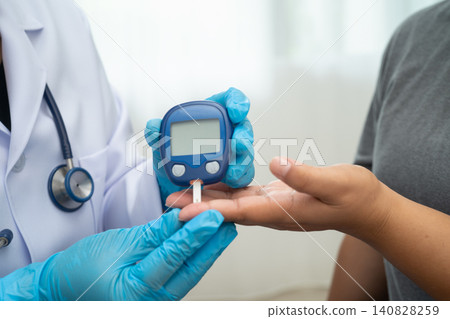 Doctor check diabetes from finger blood sugar level with digital glucose monitor measure and test stripe. 140828259