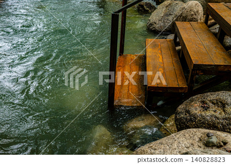 Wooden stairs descending into natural river Wooden stairs descending into natural river 140828823