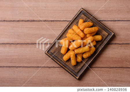 Mozzarella cheese sticks, breaded and fried with salt and tomato sauce, for takeaway. Cheese sticks Mozzarella cheese sticks, breaded and fried with salt and tomato sauce, for takeaway. Cheese sticks 140828936