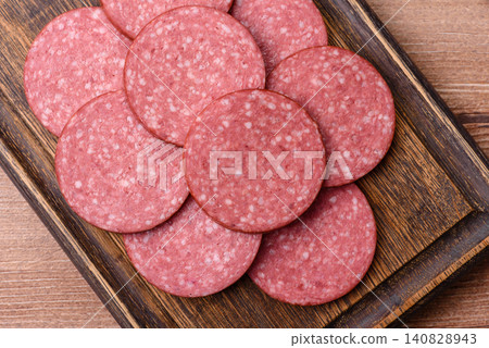 Slices of smoked salami or pepperoni for making sandwiches or pizza at home. Sausage slices Slices of smoked salami or pepperoni for making sandwiches or pizza at home. Sausage slices 140828943