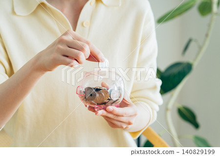A young woman's hands as she saves money A young woman's hands as she saves money 140829199