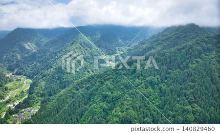從流經富山縣和新潟縣交界處的堺川下游眺望山巒。 從流經富山縣和新潟縣交界處的堺川下游眺望山巒。 140829460