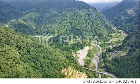 從流經富山縣和新潟縣交界處的堺川下游眺望山巒。 從流經富山縣和新潟縣交界處的堺川下游眺望山巒。 140829461