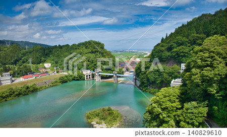 The red Aimoto Bridge spanning the Kurobe River and the surrounding area of the vast Kurobe River alluvial fan. The red Aimoto Bridge spanning the Kurobe River and the surrounding area of the vast Kurobe River alluvial fan. 140829610