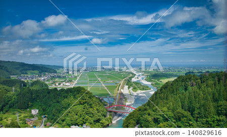 The red Aimoto Bridge spanning the Kurobe River and the surrounding area of the vast Kurobe River alluvial fan. The red Aimoto Bridge spanning the Kurobe River and the surrounding area of the vast Kurobe River alluvial fan. 140829616