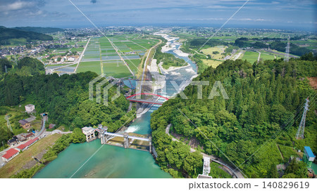 The red Aimoto Bridge spanning the Kurobe River and the surrounding area of the vast Kurobe River alluvial fan. The red Aimoto Bridge spanning the Kurobe River and the surrounding area of the vast Kurobe River alluvial fan. 140829619